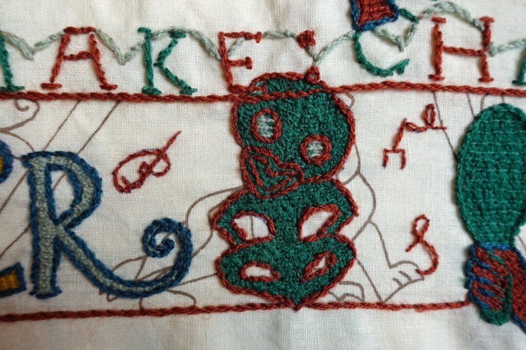 An embroidered hei-tiki, a Maori symbol. 