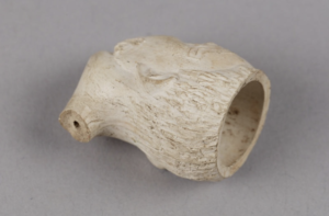 A small white clay pipe shaped into a tattooed Maori head
